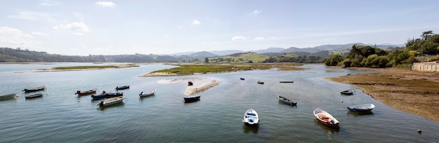 Bunch of boats in water with a clear sky