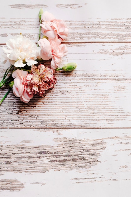 오래 된 나무 테이블에 꽃 봉 오리와 카네이션 꽃의 무리