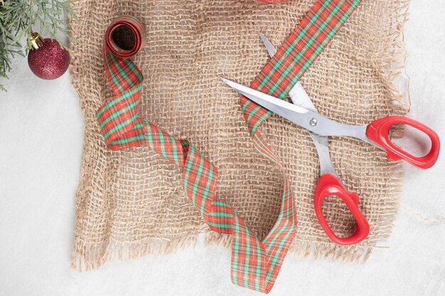 Bunch of Christmas decorations with scissors on burlap