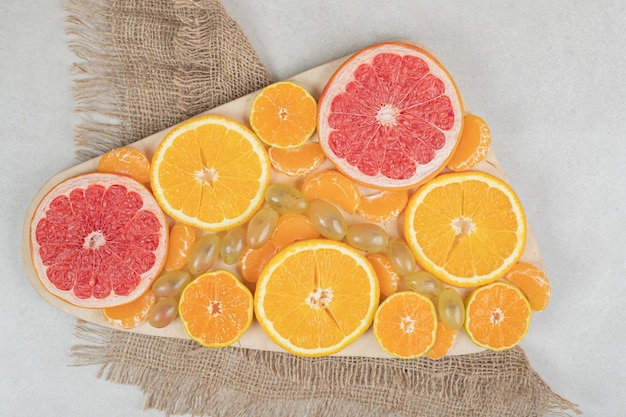 Bunch of citrus fruit slices on wooden board. 