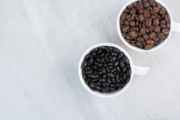 Bunch of coffee beans and chocolate drops in cups