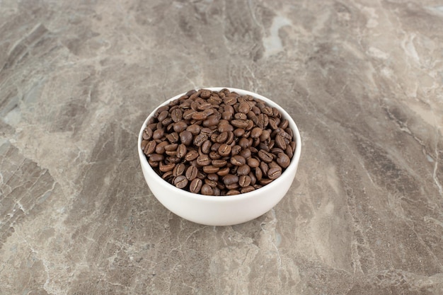 Bunch of coffee beans in white bowl