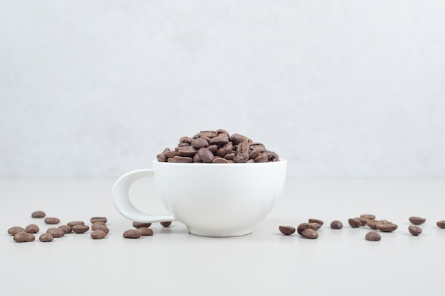 Bunch of coffee beans in white mug