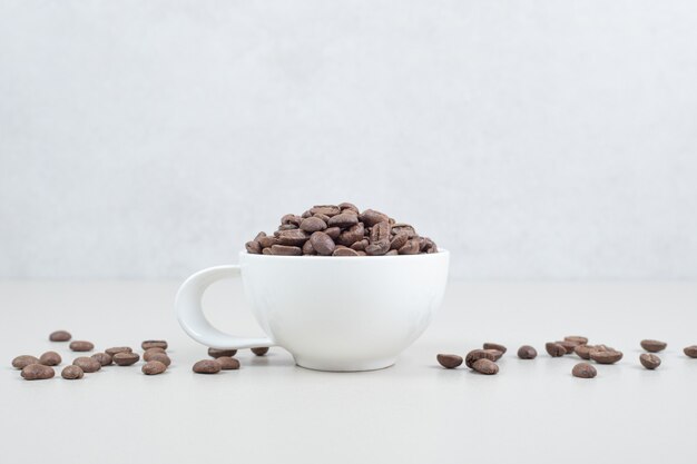 白いマグカップのコーヒー豆の束