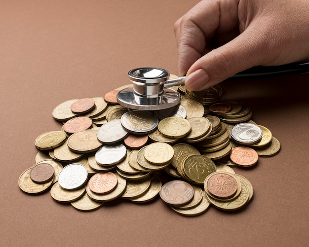 Bunch of coins with person using a stethoscope