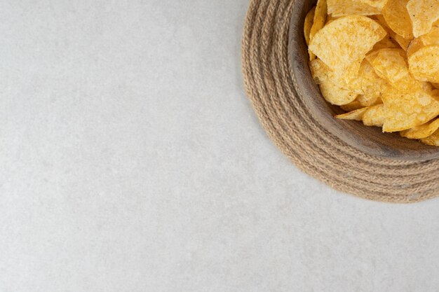 Bunch of crispy chips in wooden bowl
