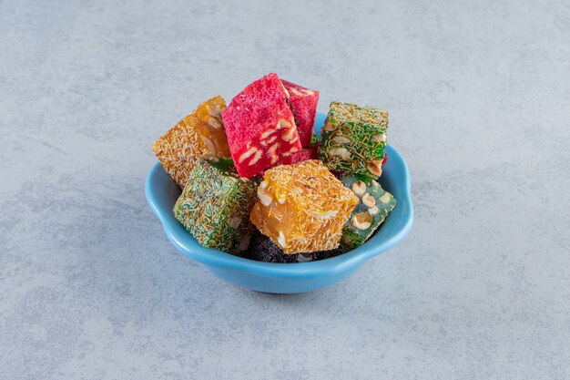 Bunch of dried fruit pulps with nuts in blue bowl.