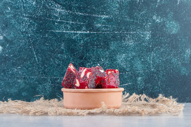 Bunch of dried red fruit pulps with nuts in ceramic bowl.