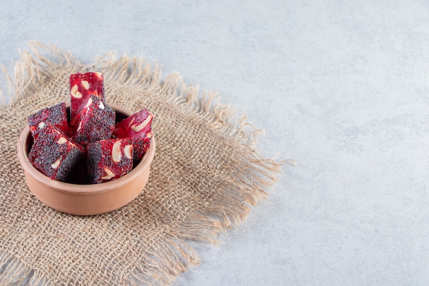 Bunch of dried red fruit pulps with nuts in ceramic bowl.