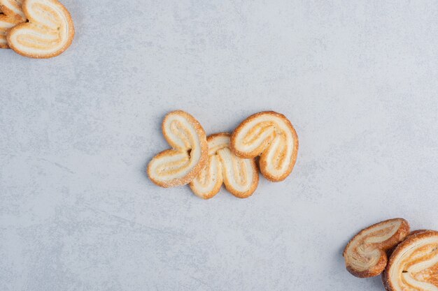 Bunch of flaky cookies displayed on marble surface