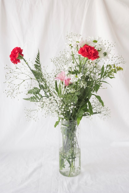 Bunch of flowers with green leaves in vase