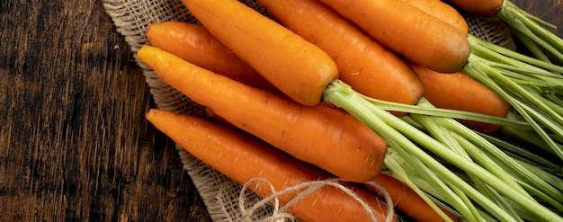 Free photo bunch of fresh carrots on wooden table