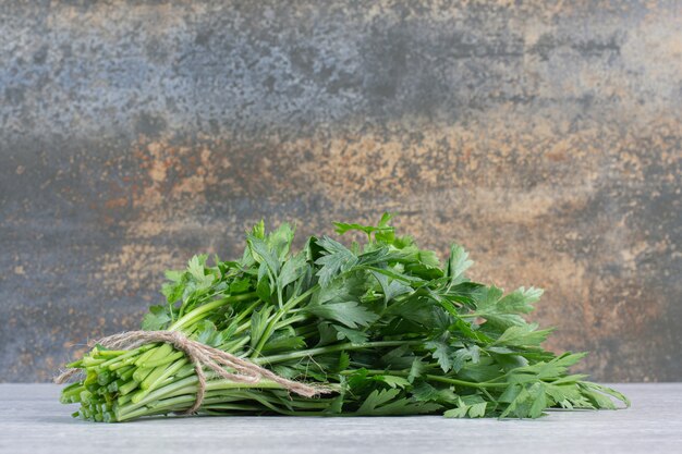 Bunch of fresh coriander leaves on stone surface. High quality photo