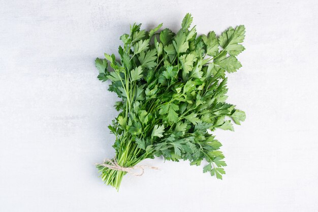 Bunch of fresh coriander leaves on stone surface. High quality photo