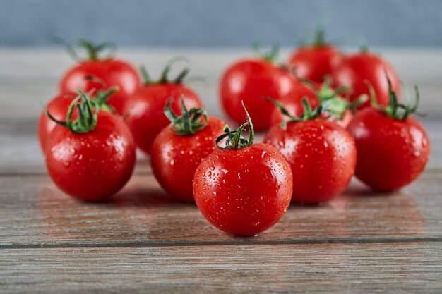 Bunch of fresh juicy tomatoes on wooden table.