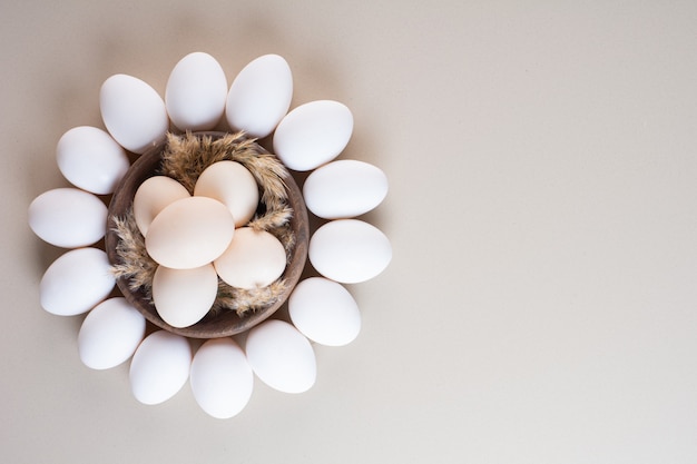 Bunch of fresh organic raw eggs placed on beige table.