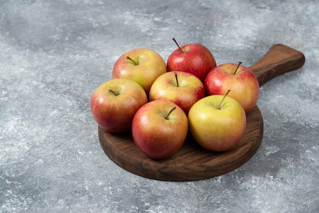 Mazzo di mele fresche mature poste sulla tavola di legno.