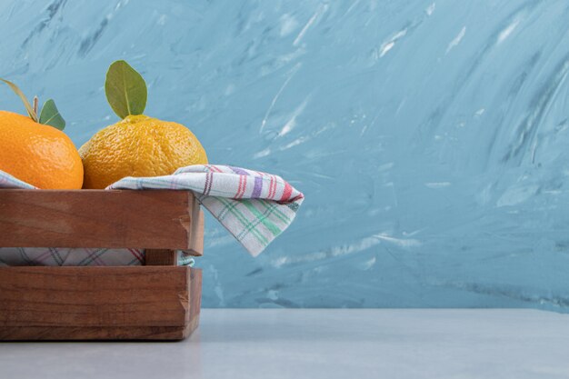 Bunch of fresh tangerines in wooden box