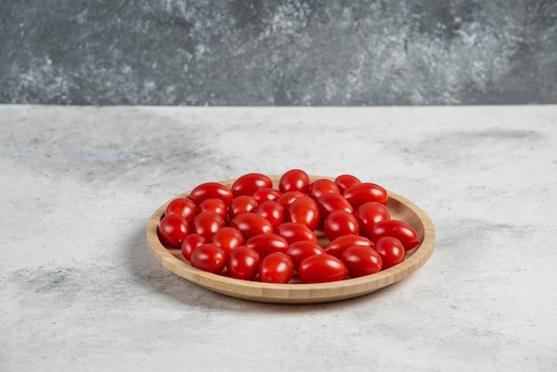木の皿にフレッシュトマトの束。
