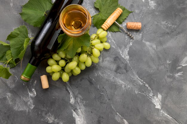 Bunch of grapes with bottle of wine on marble background