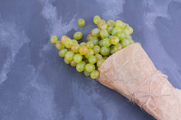 A bunch of green grapes on blue table.