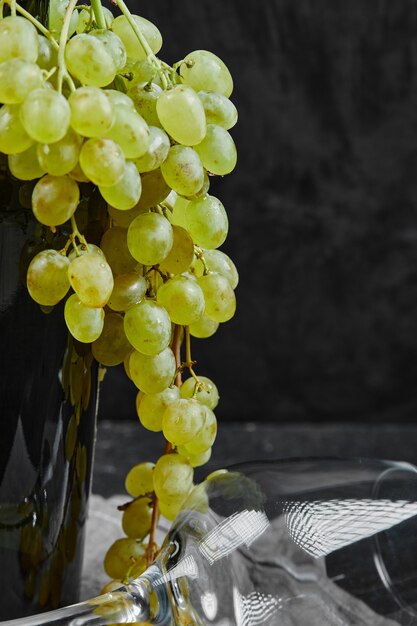 Гроздь зеленого винограда на бутылке вина.