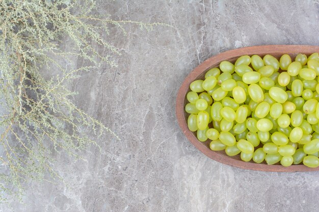 Bunch of green grapes in wooden bowl. 
