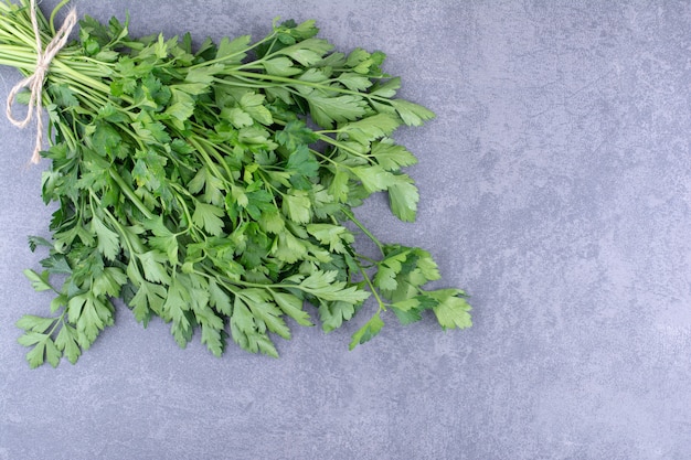 bunch of green parsley on concrete background.