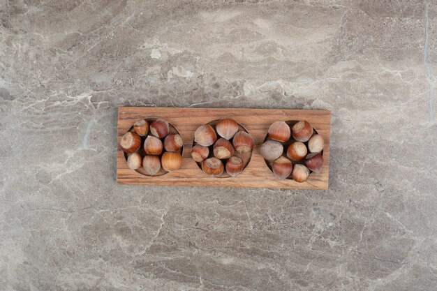 대리석 벽에 나무 접시에 헤이즐넛의 무리.