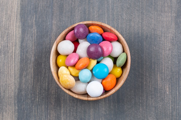 Бесплатное фото Букет из разноцветных конфет в деревянной миске