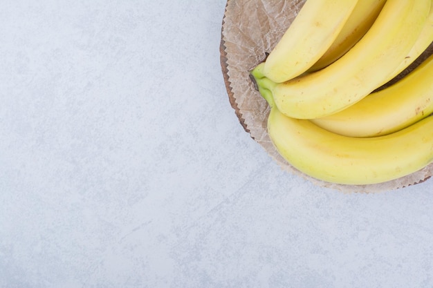 무료 사진 나무 접시에 익은 과일 바나나의 무리입니다. 고품질 사진