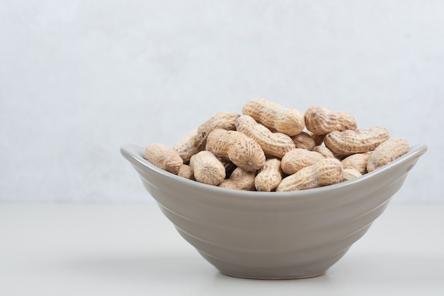 Bunch of organic peanuts in ceramic bowl