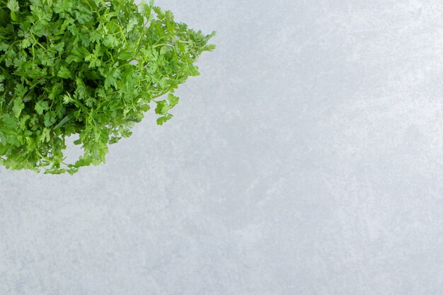 A bunch parsley in the glass , on the marble.