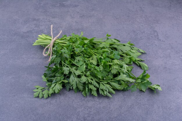 A bunch of parsley isolated on blue surface