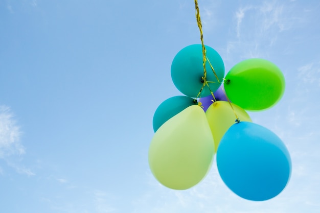 Foto gratuita grappolo di palloncini di colore pastello che galleggia in aria