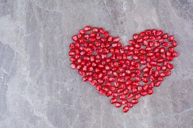 Bunch of pomegranate seeds formed like heart. 