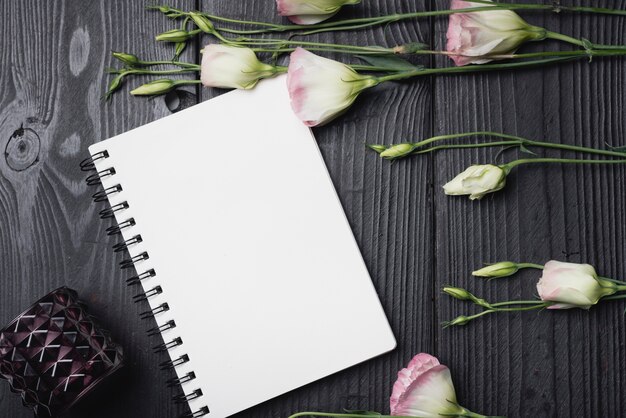 Bunch of purple eustoma flowers on blank spiral notebook