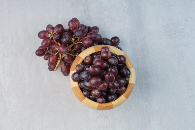 Free photo bunch of purple grapes in bucket and on table. high quality photo