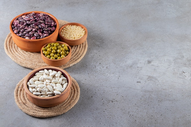 Bunch of raw lentils, beans and rice on stone background. 