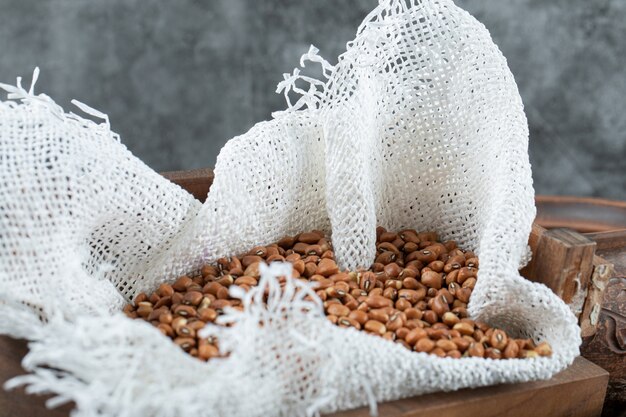 Bunch of red beans in wooden box with burlap.