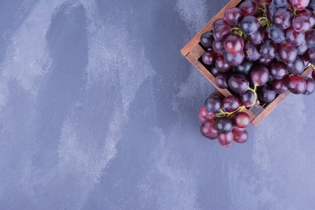 Bunch of red grapes in a rustic platter.