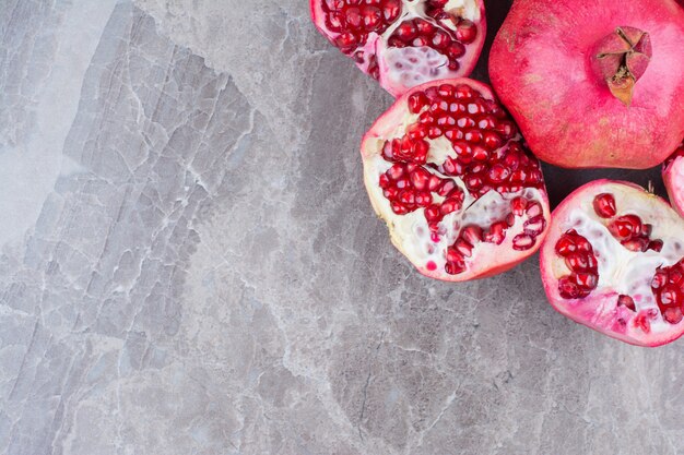 Bunch of red pomegranates on stone background. 