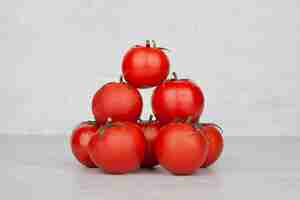 Foto gratuita mazzo di pomodori rossi sul tavolo bianco.