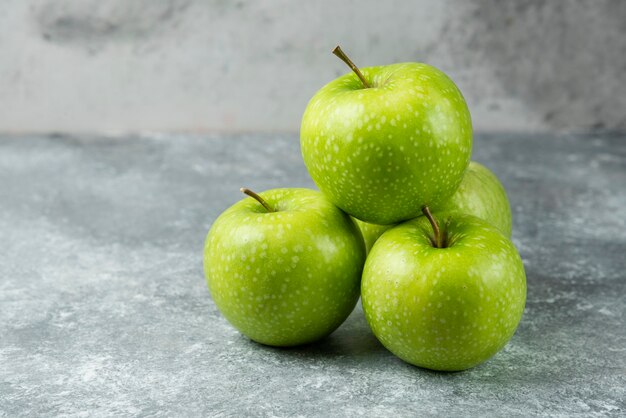 Bunch of ripe apples on marble.