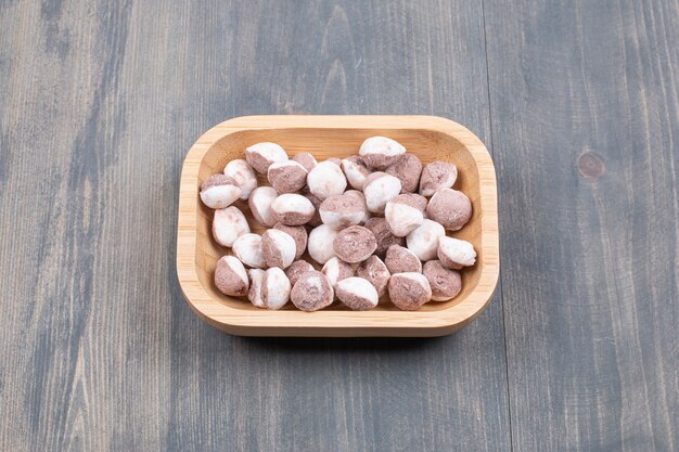 Bunch of small biscuits on wooden plate