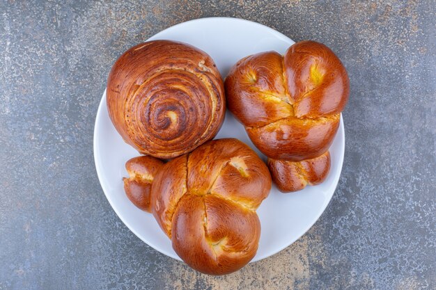 Bunch of sweet buns on a platter on marble surface