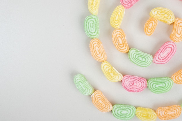 Bunch of sweet jelly candies on beige surface