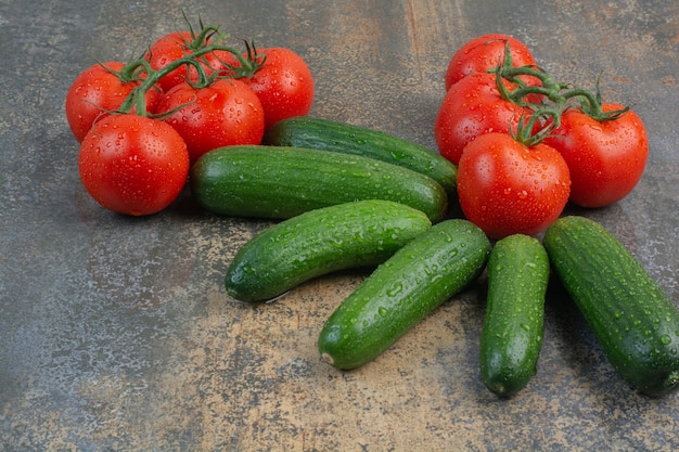 Foto gratuita mazzo di pomodori e cetrioli su marmo.