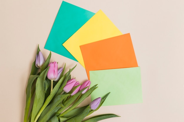 Foto gratuita mazzo di tulipani e carte colorate