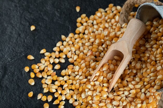 Bunch of uncooked corn grains on dark surface